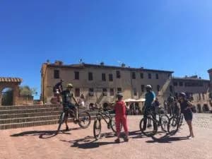 E-bike group pausing in a Tuscan village square